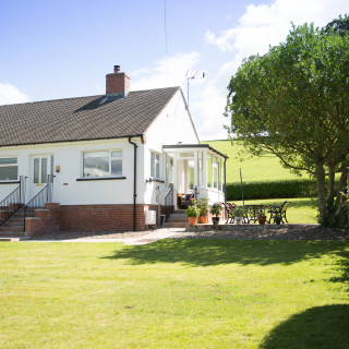 Front of Wall & Lakes holiday cottage, Brampton, Cumbria, large garden fields behind