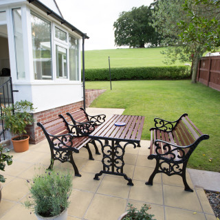 “Sunny patio with garden seating at Wall & Lakes Holiday Cottage, Brampton, Cumbria