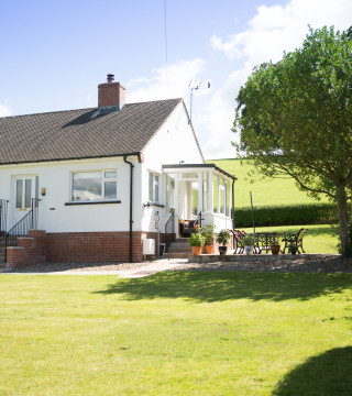 Front of Wall & Lakes holiday cottage, Brampton, Cumbria, large garden fields behind